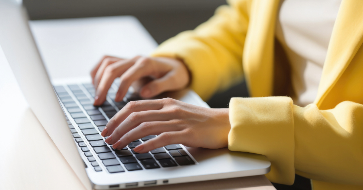 Naisen kädet tietokoneen näppäimistöllä